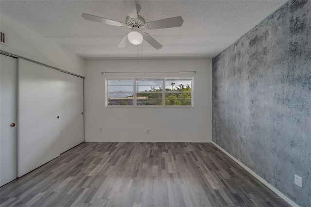 2441 Persian Dr Unit 61, Clearwater, FL 33763 - unfurnished bedroom with wood finished floors, a closet, a textured ceiling, and a ceiling fan