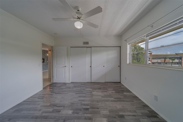 2441 Persian Dr Unit 61, Clearwater, FL 33763 - unfurnished bedroom featuring a textured ceiling, wood finished floors, a closet, and a ceiling fan