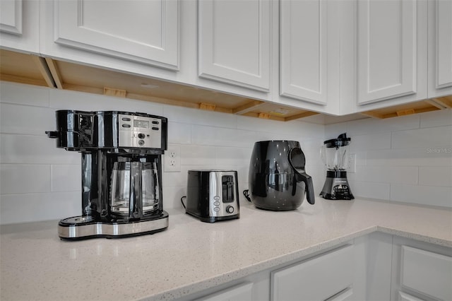 1430 Reunion Blvd, Reunion, FL 34747 - kitchen view of tasteful backsplash, white cabinetry, and light stone counters