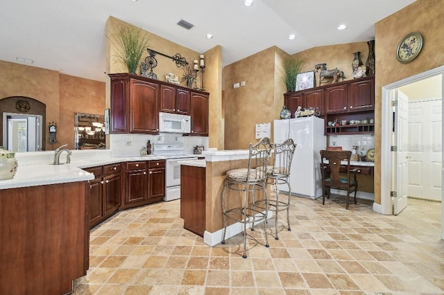 3402 Stonebridge Trl, Valrico, FL 33596 - kitchen with white appliances, a breakfast bar, high vaulted ceiling, light countertops, and a kitchen island