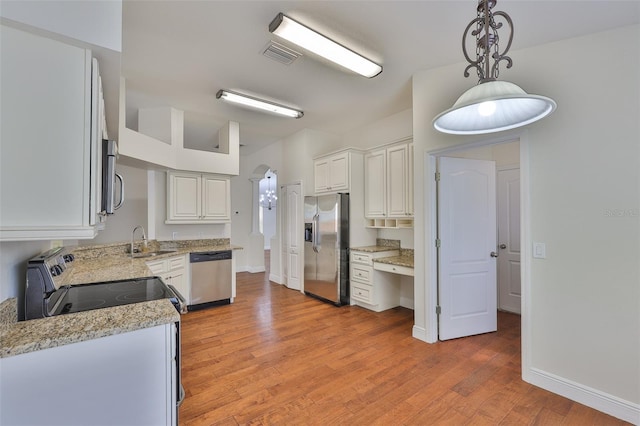 11726 S Stone Ln, Riverview, FL 33569 - kitchen featuring appliances with stainless steel finishes, a sink, light wood-style flooring, decorative light fixtures, and light stone countertops