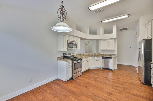 11726 S Stone Ln, Riverview, FL 33569 - kitchen featuring appliances with stainless steel finishes, baseboards, light wood-style flooring, lofted ceiling, and decorative light fixtures