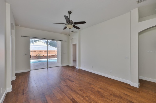 11726 S Stone Ln, Riverview, FL 33569 - unfurnished room with arched walkways, dark wood-type flooring, ceiling fan, and baseboards