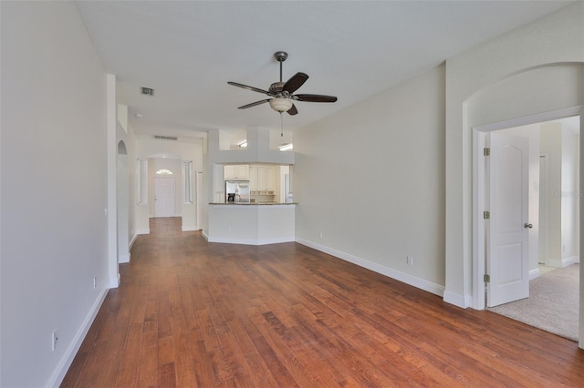 11726 S Stone Ln, Riverview, FL 33569 - unfurnished living room with ceiling fan, arched walkways, wood finished floors, and baseboards