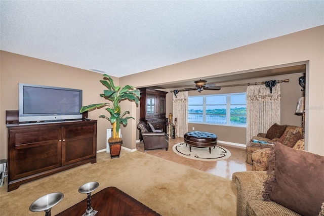 100 Bluff View Dr Unit 514C, Belleair Bluffs, FL 33770 - carpeted living room with baseboards, a ceiling fan, and a textured ceiling