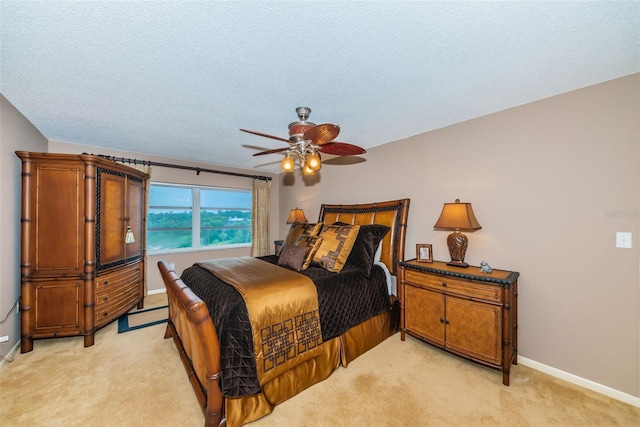 100 Bluff View Dr Unit 514C, Belleair Bluffs, FL 33770 - bedroom with light colored carpet, baseboards, a textured ceiling, and a ceiling fan