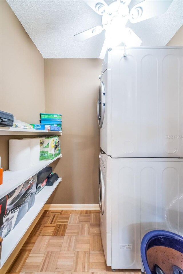 100 Bluff View Dr Unit 514C, Belleair Bluffs, FL 33770 - washroom with stacked washing machine and dryer, baseboards, and ceiling fan