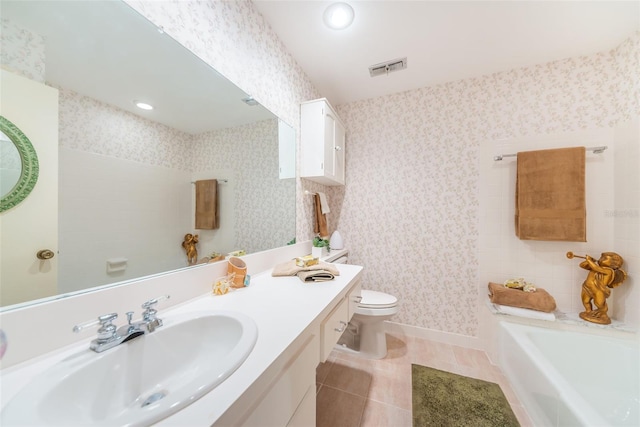 100 Bluff View Dr Unit 514C, Belleair Bluffs, FL 33770 - bathroom featuring a bath, toilet, vanity, wallpapered walls, and tile patterned floors