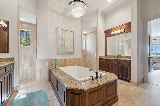 301 Bayview Dr NE, Saint Petersburg, FL 33704 - full bathroom with a chandelier, plenty of natural light, vanity, a bath, and ornamental molding