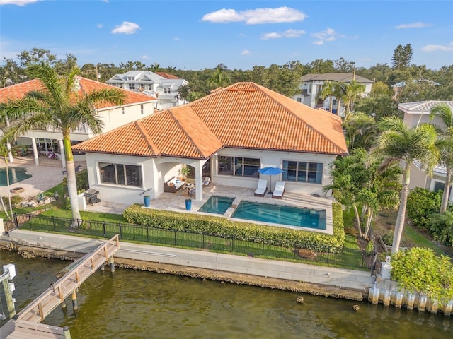 301 Bayview Dr NE, Saint Petersburg, FL 33704 - back of house with a tile roof, a fenced backyard, a patio area, and a water view