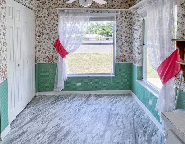 502 Chilt Dr, Brandon, FL 33510 - unfurnished dining area featuring wallpapered walls, wainscoting, a ceiling fan, and baseboards