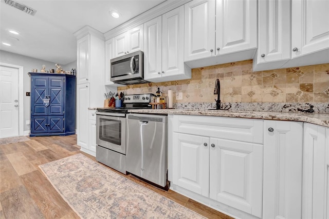 4726 W Fairview Hts, Tampa, FL 33616 - kitchen with appliances with stainless steel finishes, light wood-type flooring, white cabinets, recessed lighting, and a sink