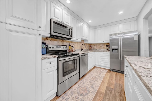 4726 W Fairview Hts, Tampa, FL 33616 - kitchen with stainless steel appliances, white cabinets, light wood-style flooring, light stone countertops, and recessed lighting