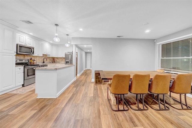 4726 W Fairview Hts, Tampa, FL 33616 - kitchen with appliances with stainless steel finishes, white cabinets, light wood-style floors, and recessed lighting