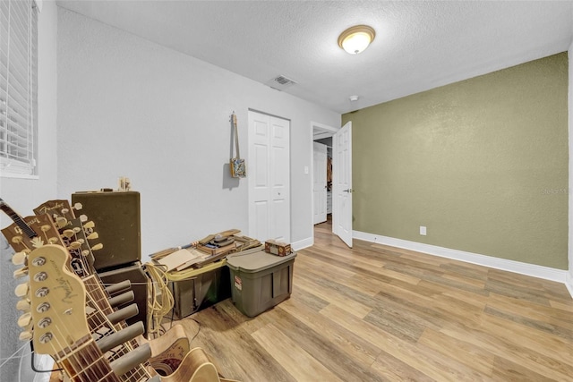 4726 W Fairview Hts, Tampa, FL 33616 - living area featuring light wood-style floors, a textured ceiling, and baseboards