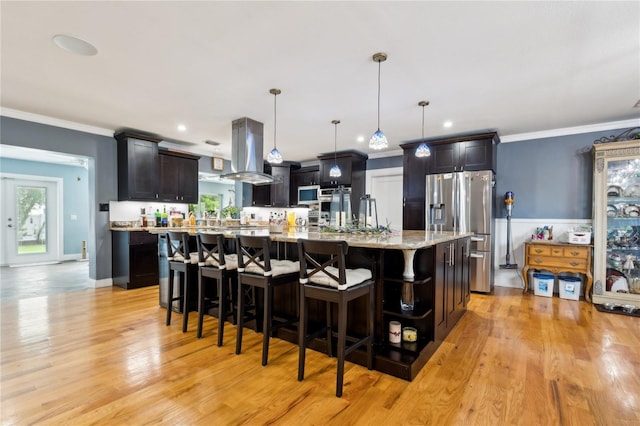 708 Westwood Cir, Brandon, FL 33511 - kitchen featuring appliances with stainless steel finishes, island exhaust hood, light wood-style flooring, a large island, and a kitchen bar