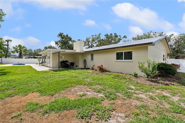 708 Westwood Cir, Brandon, FL 33511 - back of property featuring a chimney, a patio, and metal roof