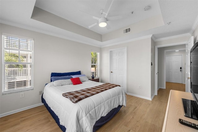 800 S Dakota Ave Unit 337, Tampa, FL 33606 - bedroom featuring a tray ceiling, light wood-style floors, multiple windows, and ornamental molding