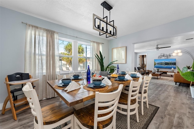 3485 Floral Dr, Largo, FL 33771 - dining space featuring light wood-style flooring, a chandelier, and a textured ceiling