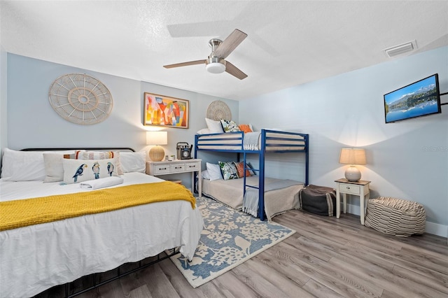3485 Floral Dr, Largo, FL 33771 - bedroom with wood finished floors, a ceiling fan, and a textured ceiling