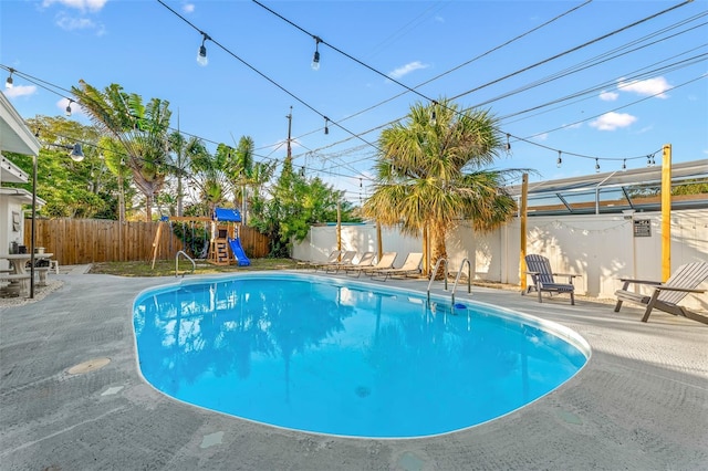 3485 Floral Dr, Largo, FL 33771 - view of swimming pool featuring a fenced backyard, a patio, and a playground