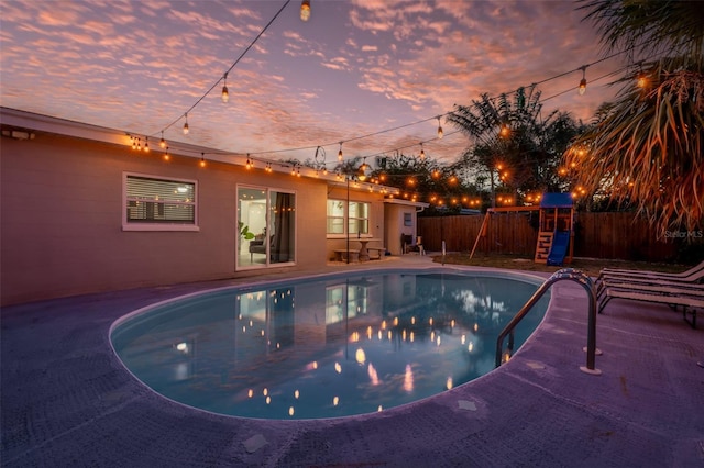 3485 Floral Dr, Largo, FL 33771 - pool at dusk featuring a playground and a patio