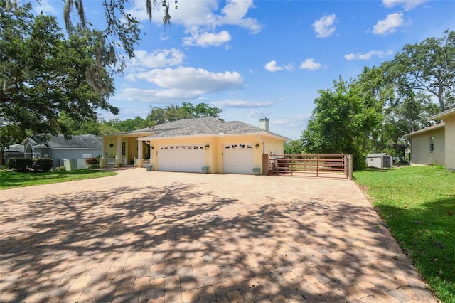 10306 Shalimar Wood Dr, Thonotosassa, FL 33592 - single story home with an attached garage, decorative driveway, a shed, stucco siding, and a gate