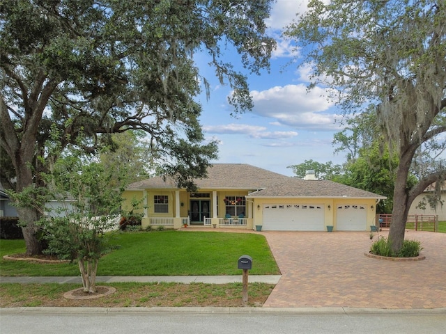 10306 Shalimar Wood Dr, Thonotosassa, FL 33592 - ranch-style house featuring a garage, decorative driveway, and covered porch