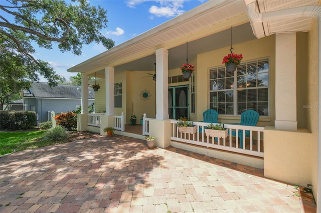 10306 Shalimar Wood Dr, Thonotosassa, FL 33592 - property entrance featuring a porch, stucco siding, and ceiling fan