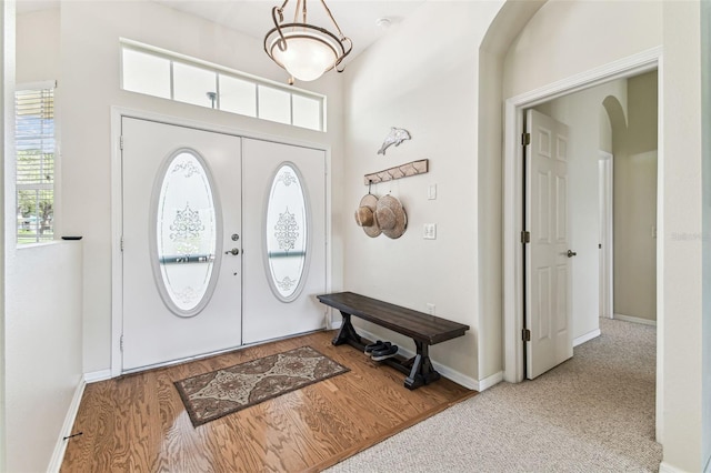 10306 Shalimar Wood Dr, Thonotosassa, FL 33592 - foyer entrance featuring healthy amount of natural light, baseboards, arched walkways, and wood finished floors