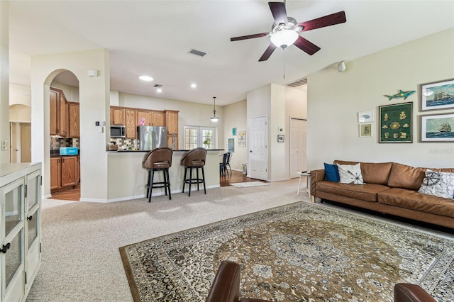 10306 Shalimar Wood Dr, Thonotosassa, FL 33592 - living room featuring light carpet, a ceiling fan, baseboards, and arched walkways