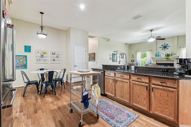 10306 Shalimar Wood Dr, Thonotosassa, FL 33592 - kitchen with a sink, stainless steel appliances, brown cabinetry, light wood-type flooring, and a ceiling fan