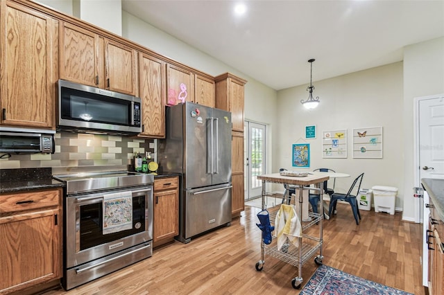 10306 Shalimar Wood Dr, Thonotosassa, FL 33592 - kitchen with appliances with stainless steel finishes, light wood-style floors, tasteful backsplash, and brown cabinetry