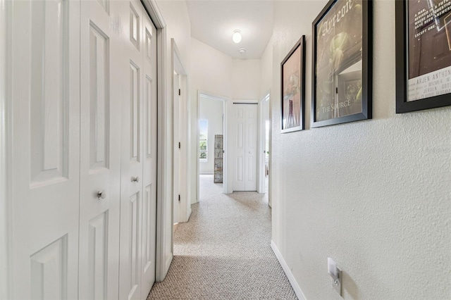 10306 Shalimar Wood Dr, Thonotosassa, FL 33592 - hallway with light colored carpet, a textured wall, and baseboards