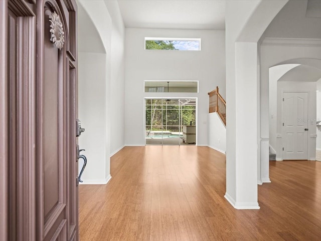 6127 Cezanne Ave, Lutz, FL 33558 - foyer with arched walkways, wood finished floors, stairway, and baseboards
