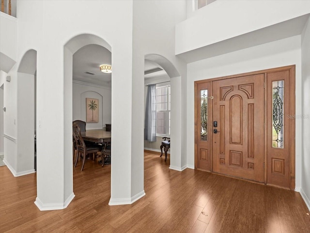 6127 Cezanne Ave, Lutz, FL 33558 - entryway featuring arched walkways, wood finished floors, baseboards, and a towering ceiling