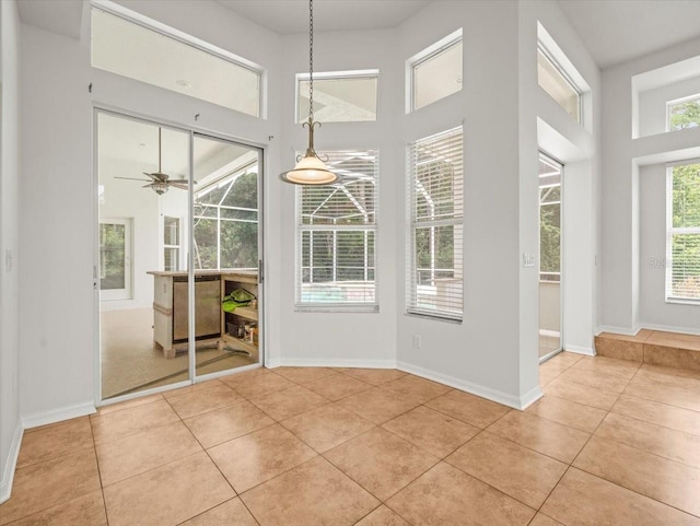 6127 Cezanne Ave, Lutz, FL 33558 - unfurnished dining area with light tile patterned floors, a high ceiling, baseboards, and ceiling fan