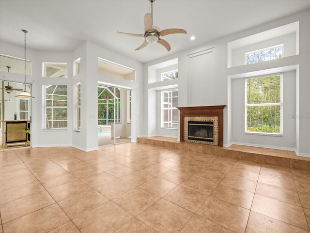 6127 Cezanne Ave, Lutz, FL 33558 - unfurnished living room featuring a ceiling fan, light tile patterned flooring, a high ceiling, a tile fireplace, and recessed lighting