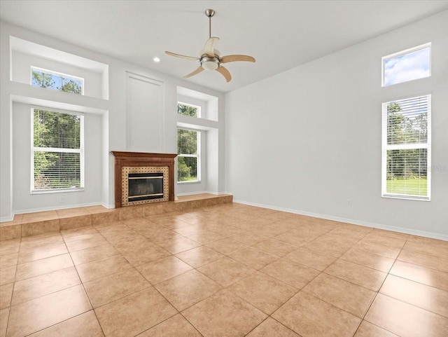 6127 Cezanne Ave, Lutz, FL 33558 - unfurnished living room with light tile patterned flooring, a ceiling fan, a premium fireplace, a high ceiling, and recessed lighting