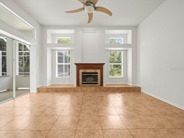 6127 Cezanne Ave, Lutz, FL 33558 - unfurnished living room featuring healthy amount of natural light, light tile patterned floors, a ceiling fan, and a tile fireplace