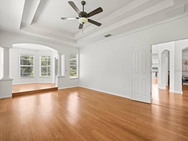 6127 Cezanne Ave, Lutz, FL 33558 - unfurnished living room with a raised ceiling, decorative columns, ceiling fan, wood finished floors, and baseboards