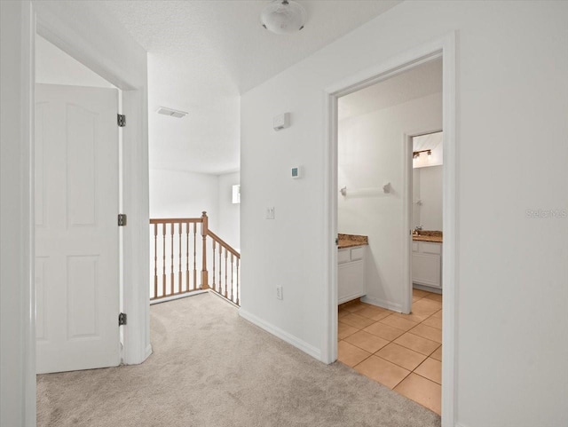 6127 Cezanne Ave, Lutz, FL 33558 - hallway featuring an upstairs landing, light carpet, baseboards, and light tile patterned floors