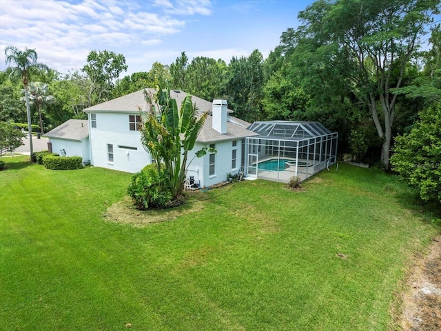 6127 Cezanne Ave, Lutz, FL 33558 - rear view of house with a lawn, a chimney, stucco siding, an outdoor pool, and a shingled roof