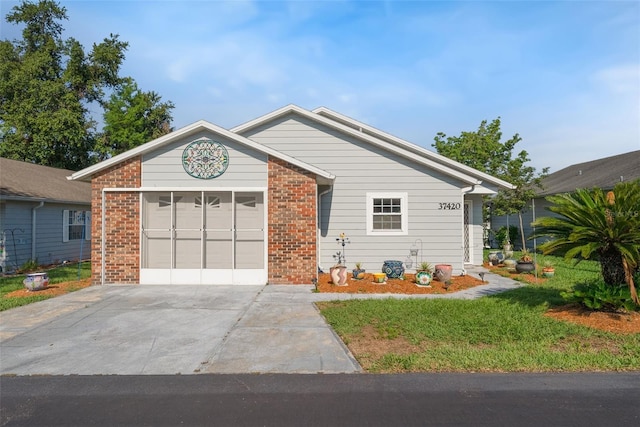 37420 Teaberry Loop, Zephyrhills, FL 33542 - ranch-style home featuring driveway, brick siding, a front yard, and an attached garage