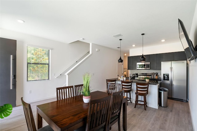 3428 Tranquil Trl, Kissimmee, FL 34747 - dining space featuring light wood-style floors, recessed lighting, and stairway