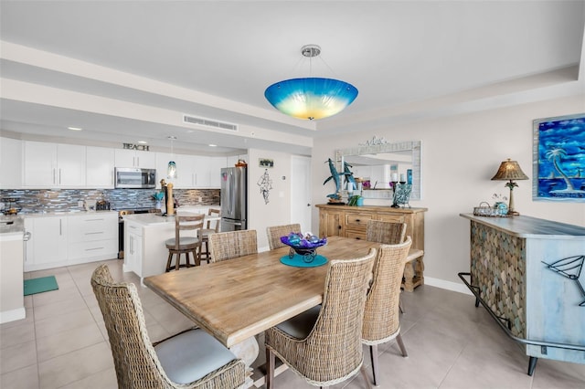 223 Island Way Unit 7F, Clearwater Beach, FL 33767 - dining area with light tile patterned floors, a tray ceiling, and baseboards