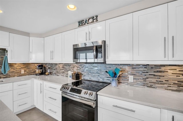 223 Island Way Unit 7F, Clearwater Beach, FL 33767 - kitchen with appliances with stainless steel finishes, white cabinetry, decorative backsplash, light stone counters, and recessed lighting