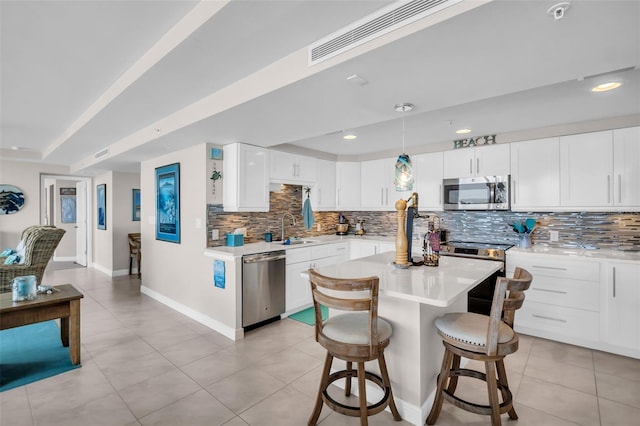 223 Island Way Unit 7F, Clearwater Beach, FL 33767 - kitchen with stainless steel appliances, a sink, decorative backsplash, light countertops, and baseboards