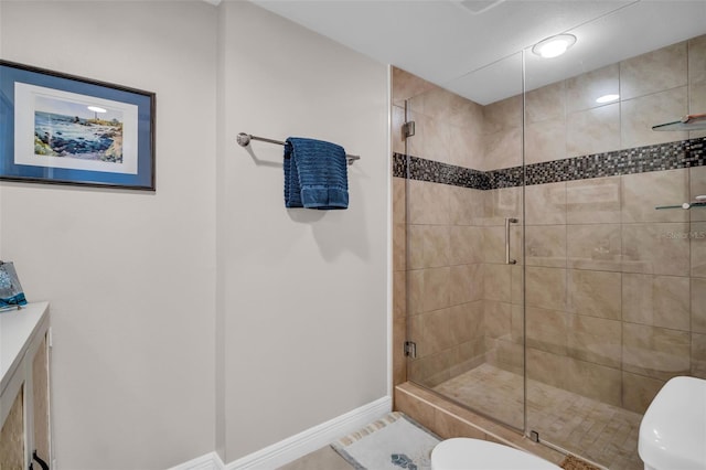 223 Island Way Unit 7F, Clearwater Beach, FL 33767 - bathroom with toilet, a stall shower, baseboards, tile patterned floors, and vanity