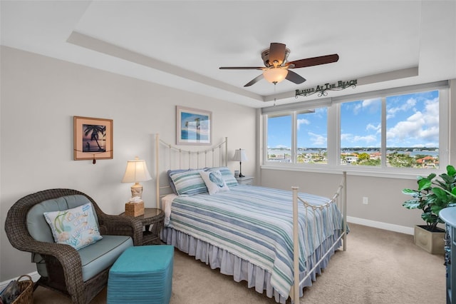 223 Island Way Unit 7F, Clearwater Beach, FL 33767 - bedroom with light colored carpet, baseboards, a raised ceiling, and a ceiling fan